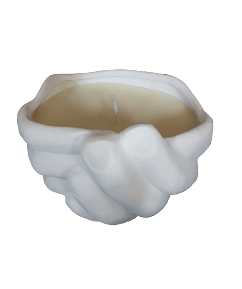 Candle in a shell-shaped holder on a black background