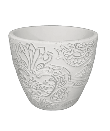 White ceramic cup with intricate paisley patterns on a black background