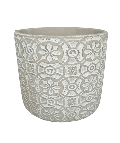 Decorative white planter with intricate patterns on a black background